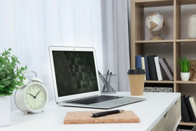 Photo of Workplace with modern laptop on desk at home