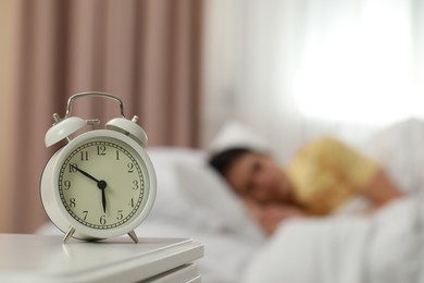 Photo of Woman sleeping in bedroom, focus on alarm clock. Space for text