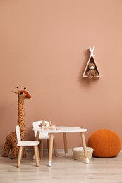 Cute child room interior with furniture, toys and wigwam shaped shelf on pink wall
