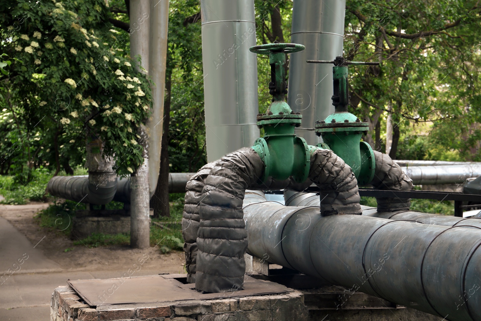 Photo of Old pipes with valve gate on city street