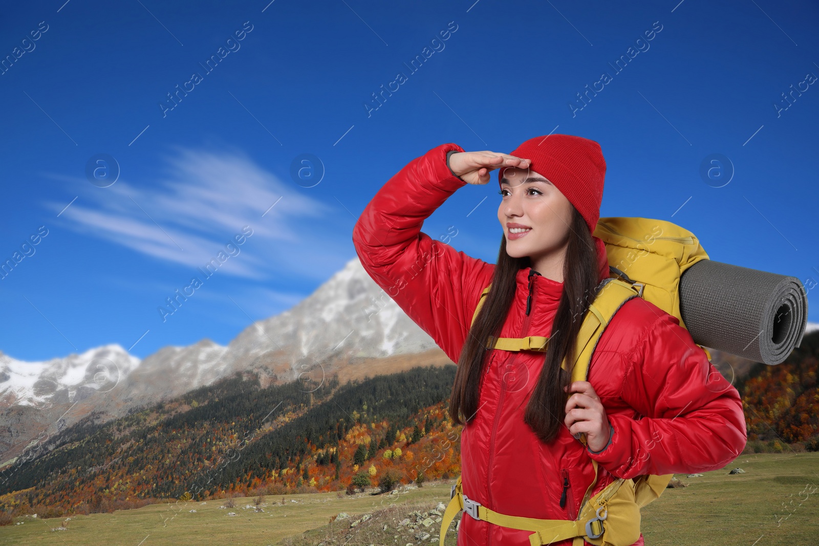 Image of Happy tourist with yellow backpack in mountains