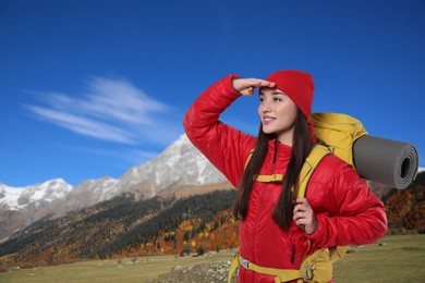 Happy tourist with yellow backpack in mountains