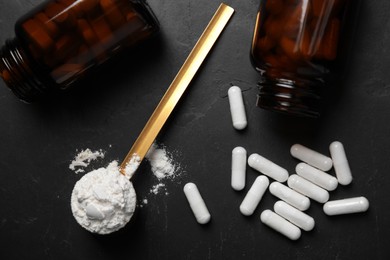 Amino acids pills and powder on black table, flat lay