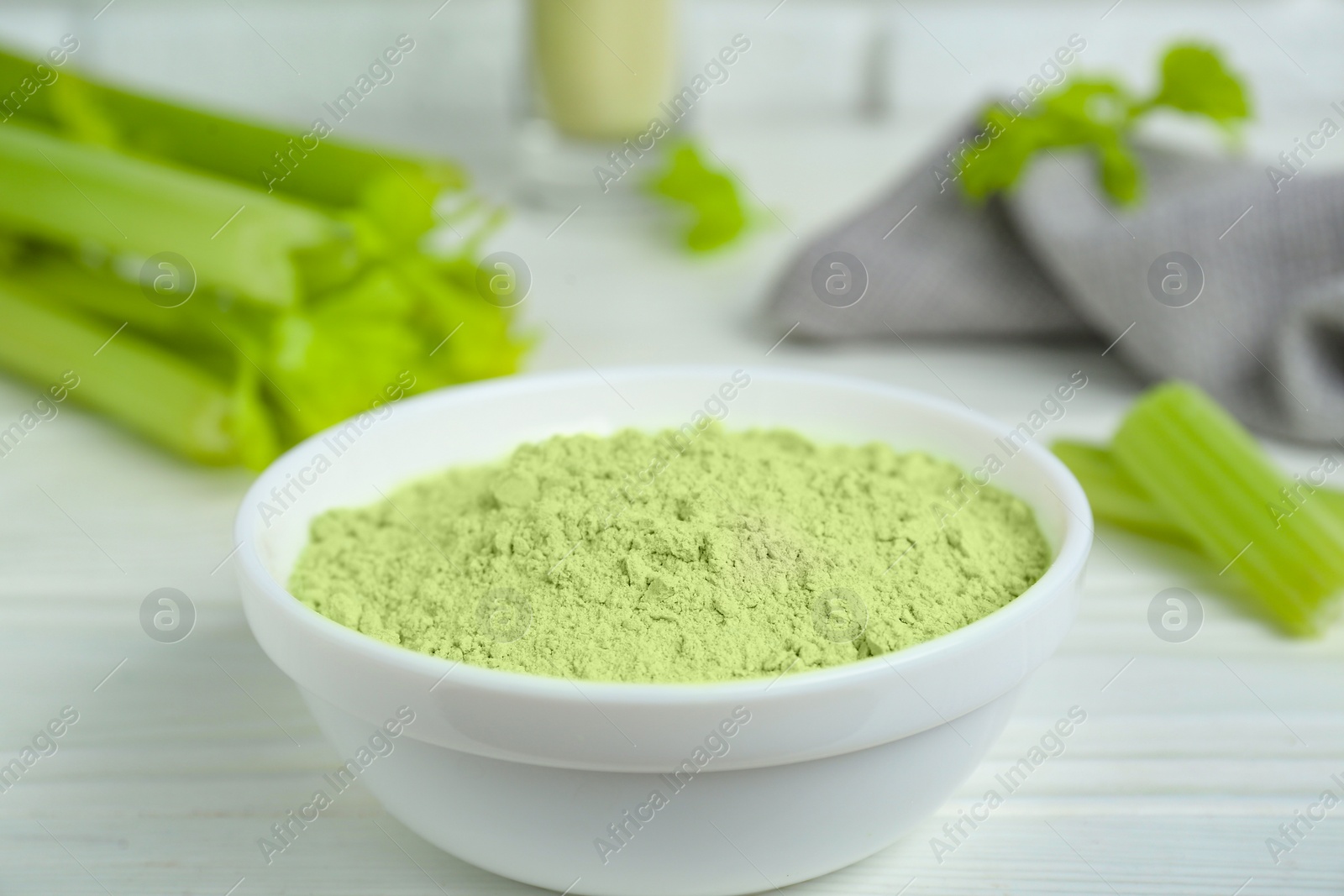 Photo of Natural celery powder in bowl on white table, closeup