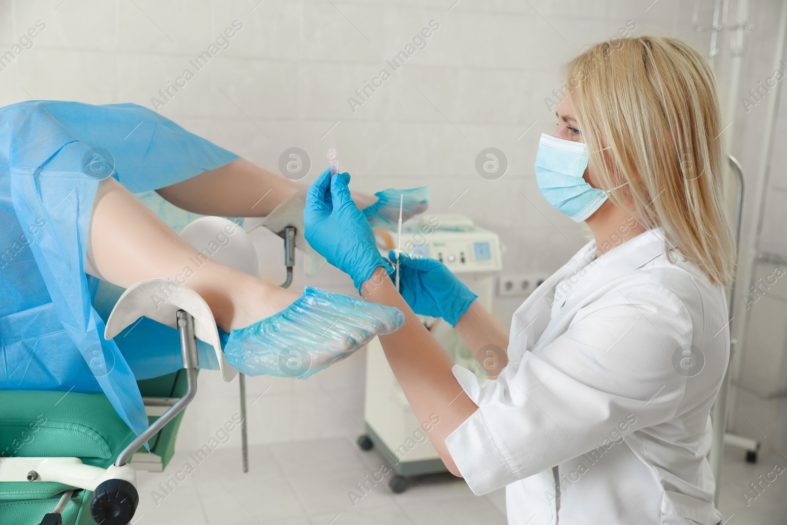 Photo of Gynecologist examining woman on chair in clinic. Health checkup