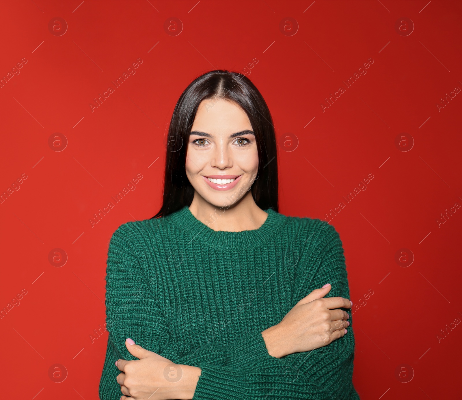 Image of Happy young woman wearing warm sweater on red background 