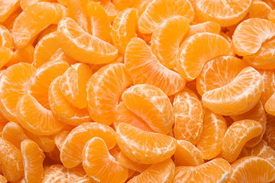 Fresh juicy tangerine segments as background, top view