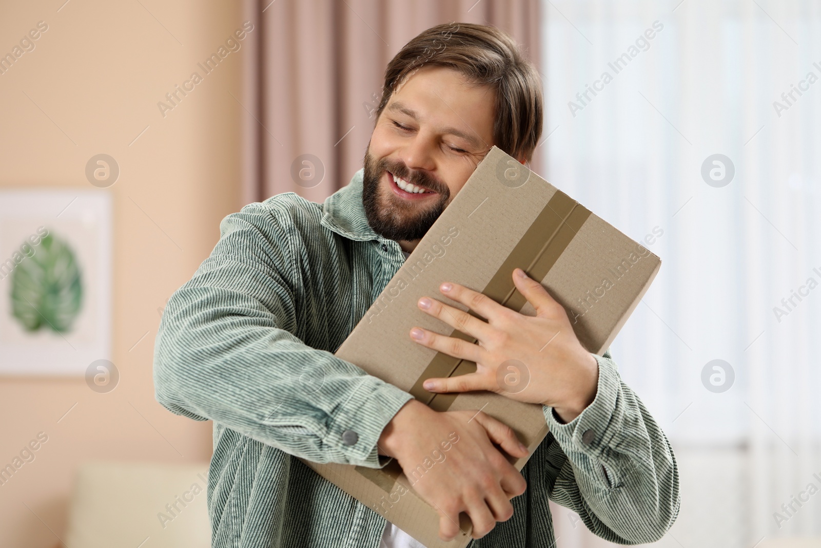 Photo of Man with parcel at home. Internet shopping