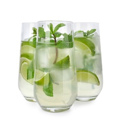 Glasses of refreshing drink with lime slices and mint on white background