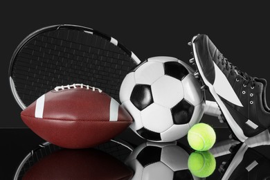 Photo of Many different sports equipment on black mirror surface