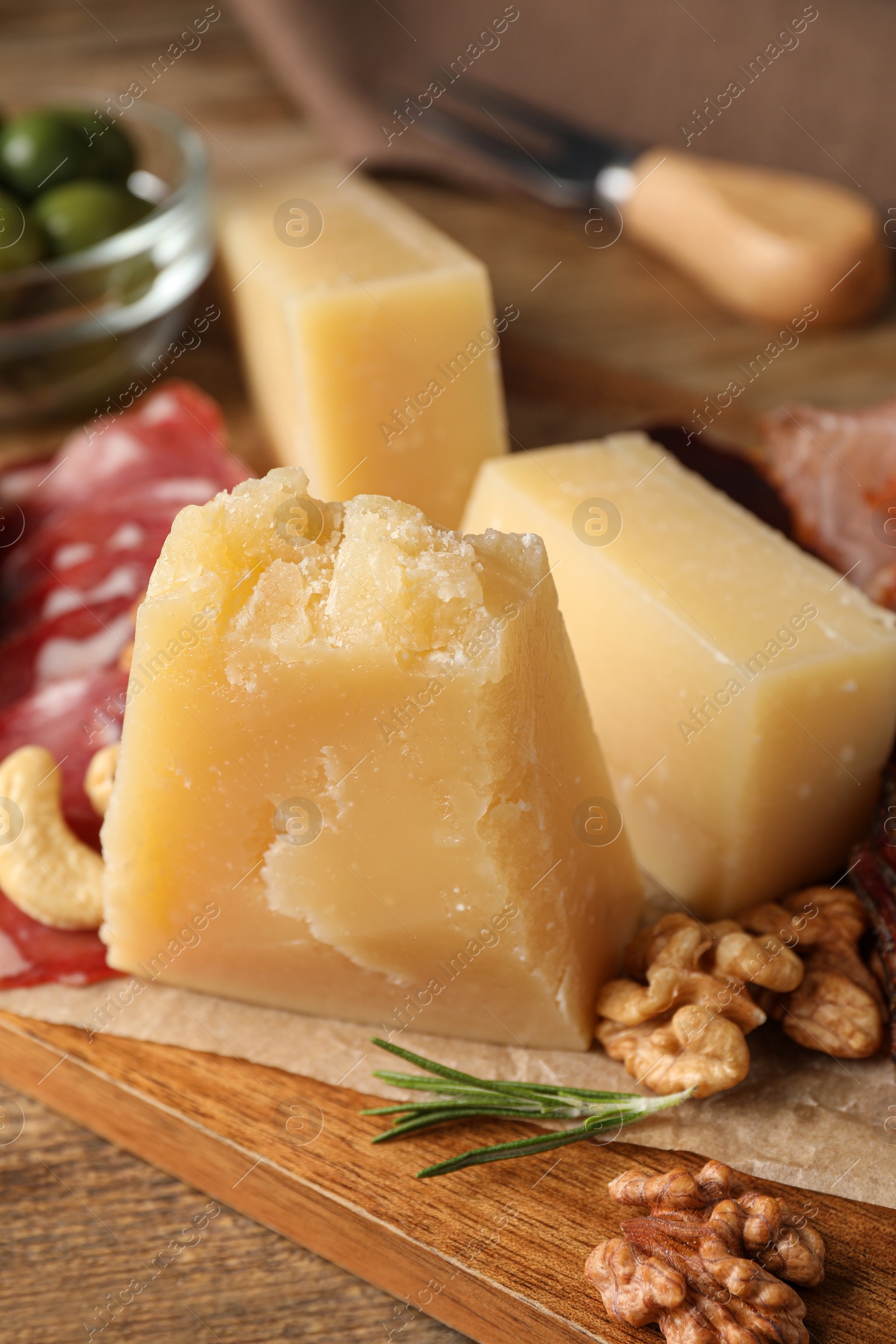 Photo of Snack platter with parmesan cheese on wooden table, closeup