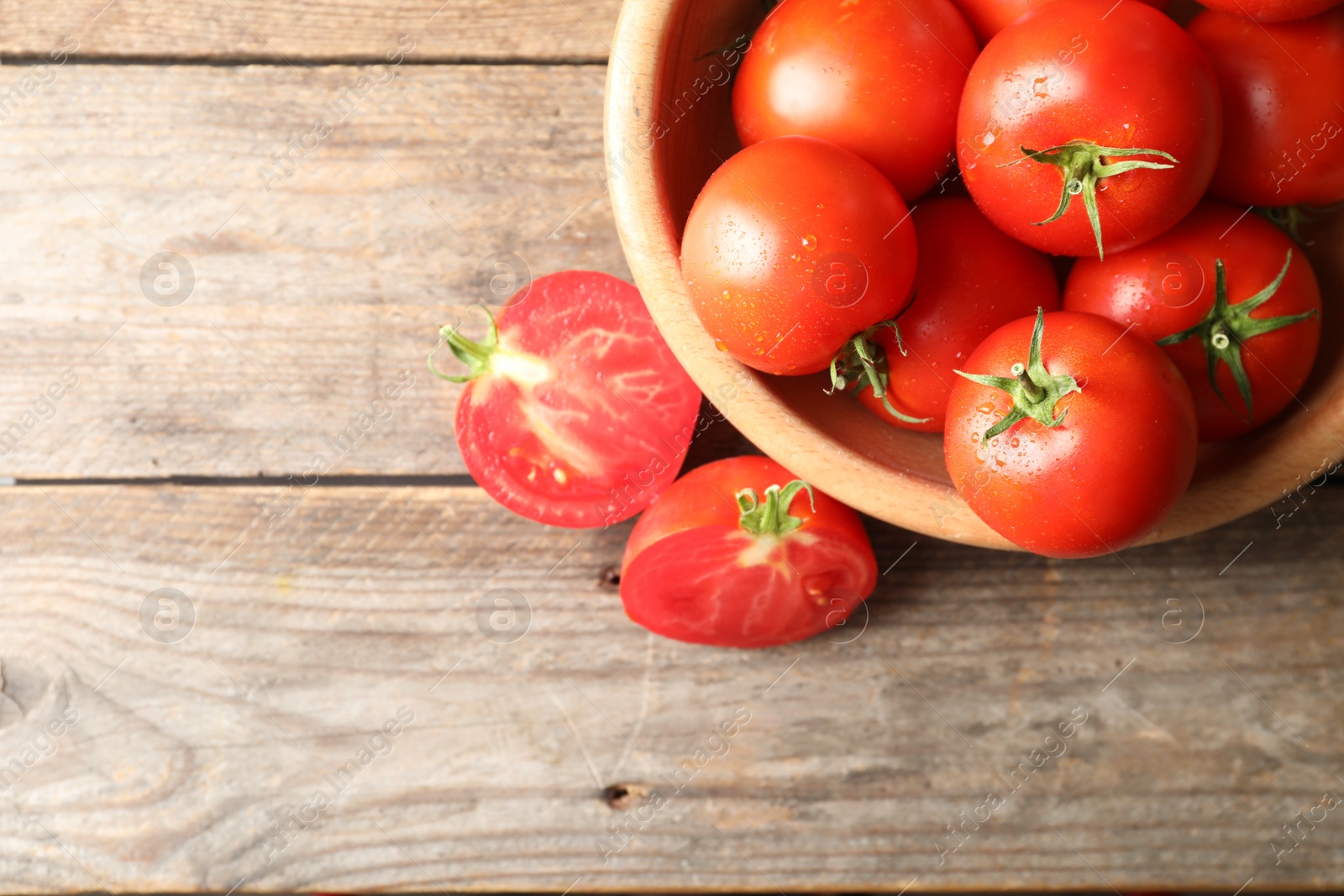 Photo of Fresh ripe tomatoes on wooden table, flat lay. Space for text