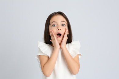 Portrait of cute little girl on light grey background