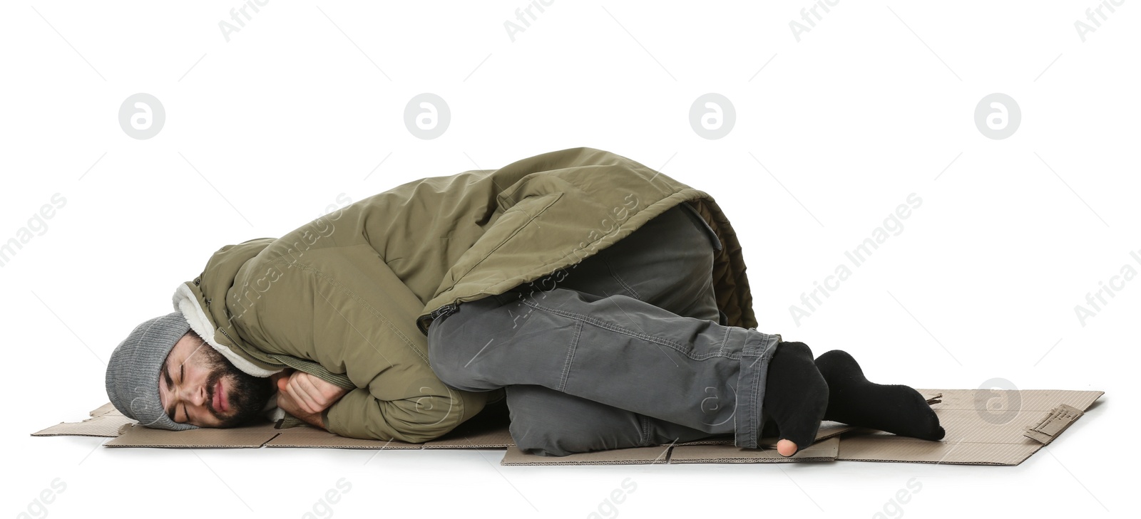Photo of Poor homeless man lying on cardboard, white background