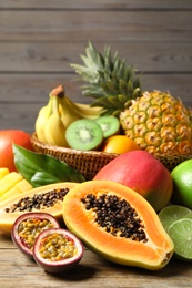 Photo of Fresh ripe papaya and other fruits on wooden table
