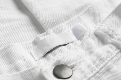 Blank clothing label on white jeans, closeup