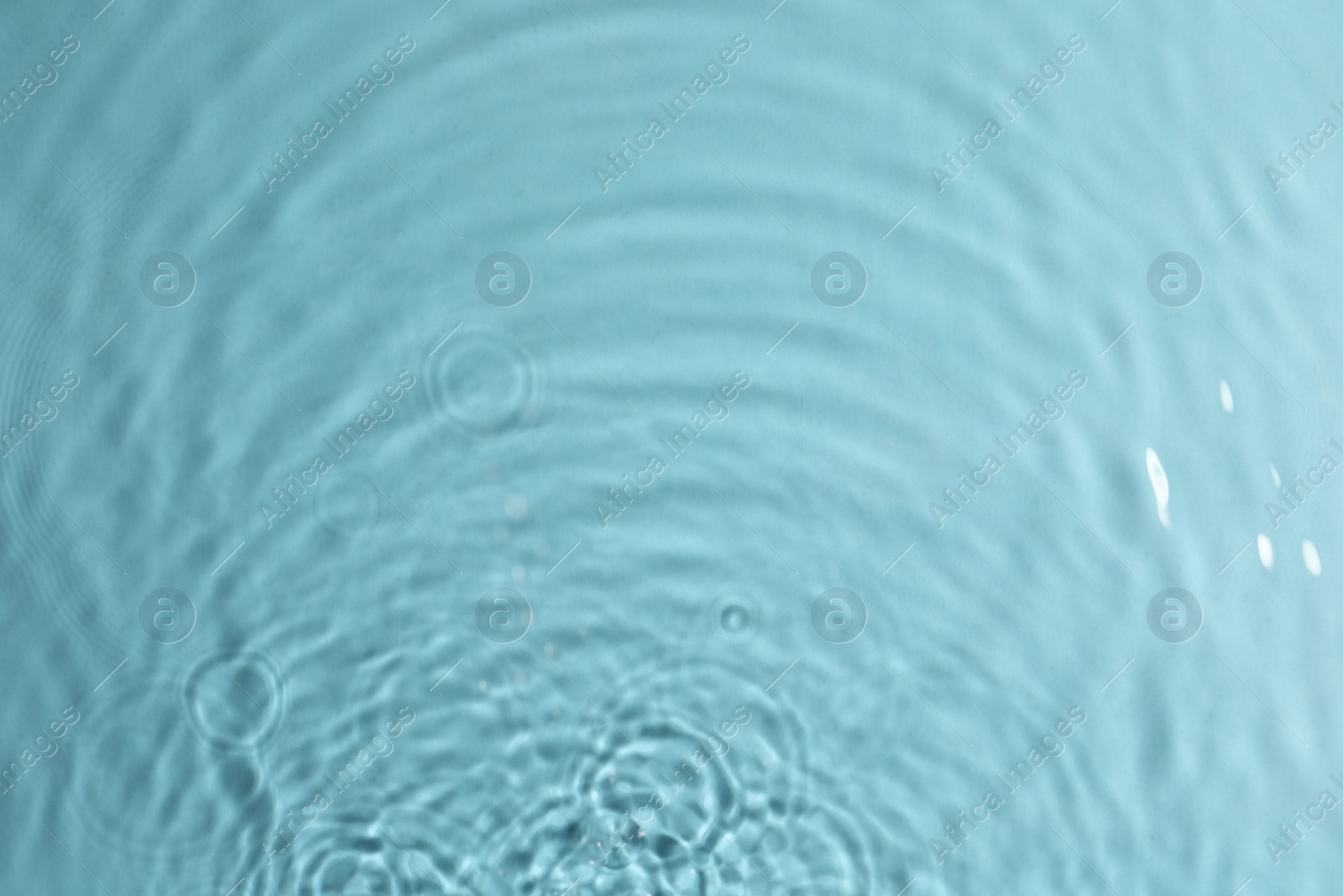 Photo of Closeup view of water with circles on turquoise background