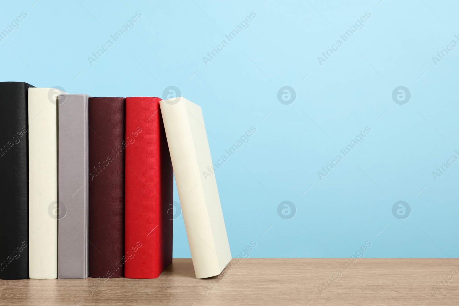 Photo of Many hardcover books on wooden table, space for text