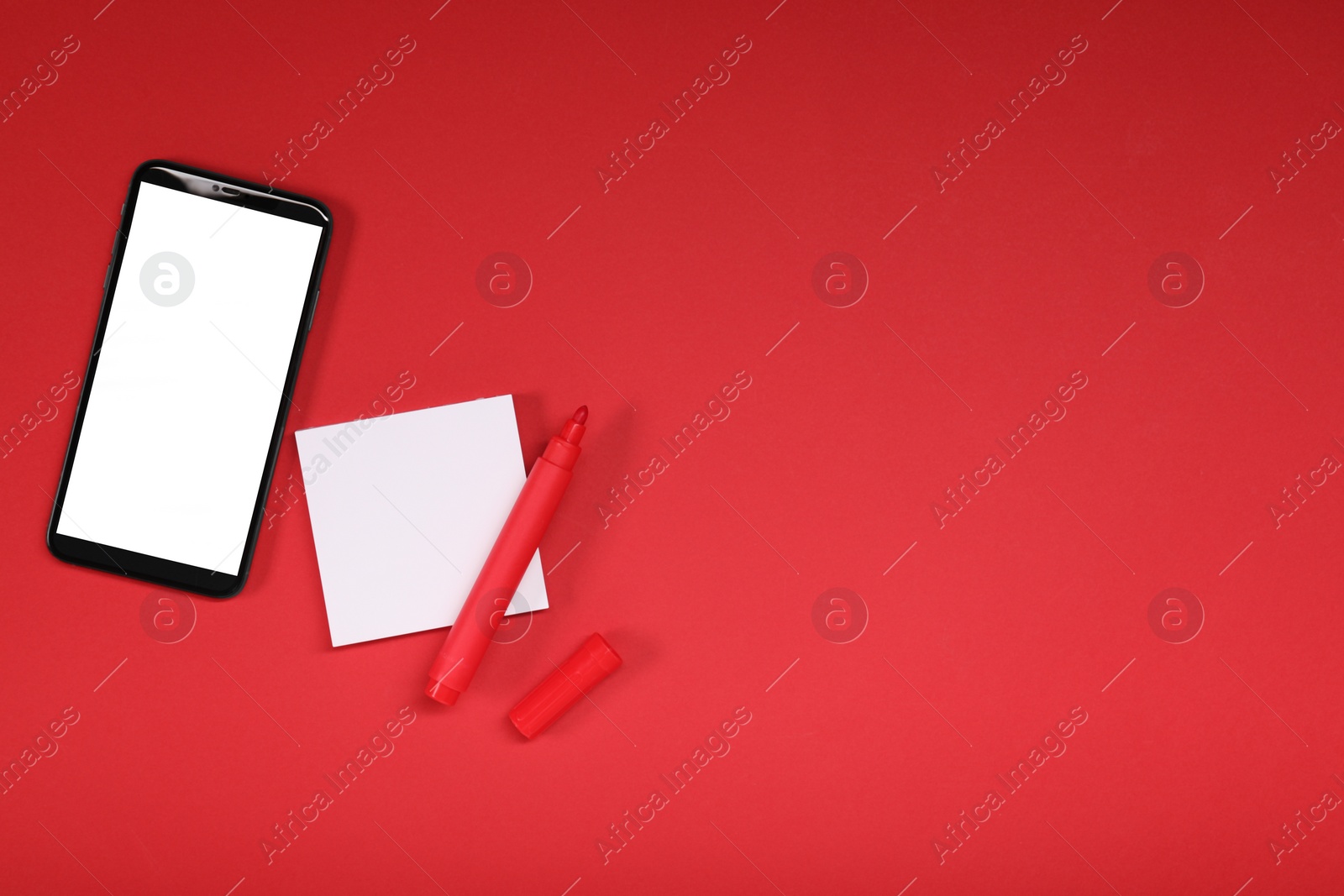 Photo of Long-distance relationship concept. Smartphone, sticky note and marker on red background, flat lay with space for text