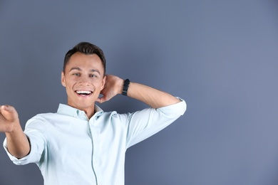Photo of Laughing man taking selfie on color background. Space for text