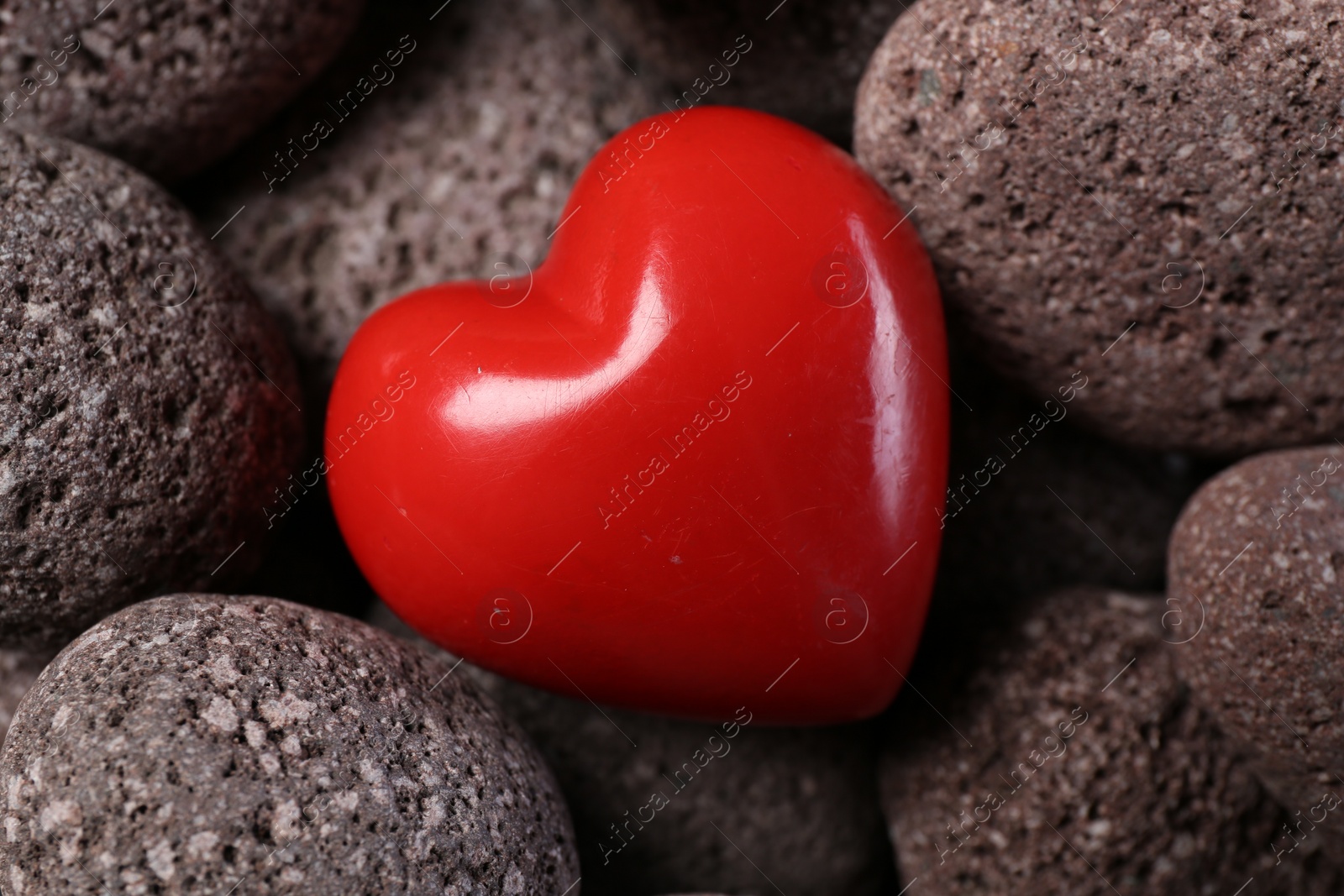 Photo of One red decorative heart on stones, above view