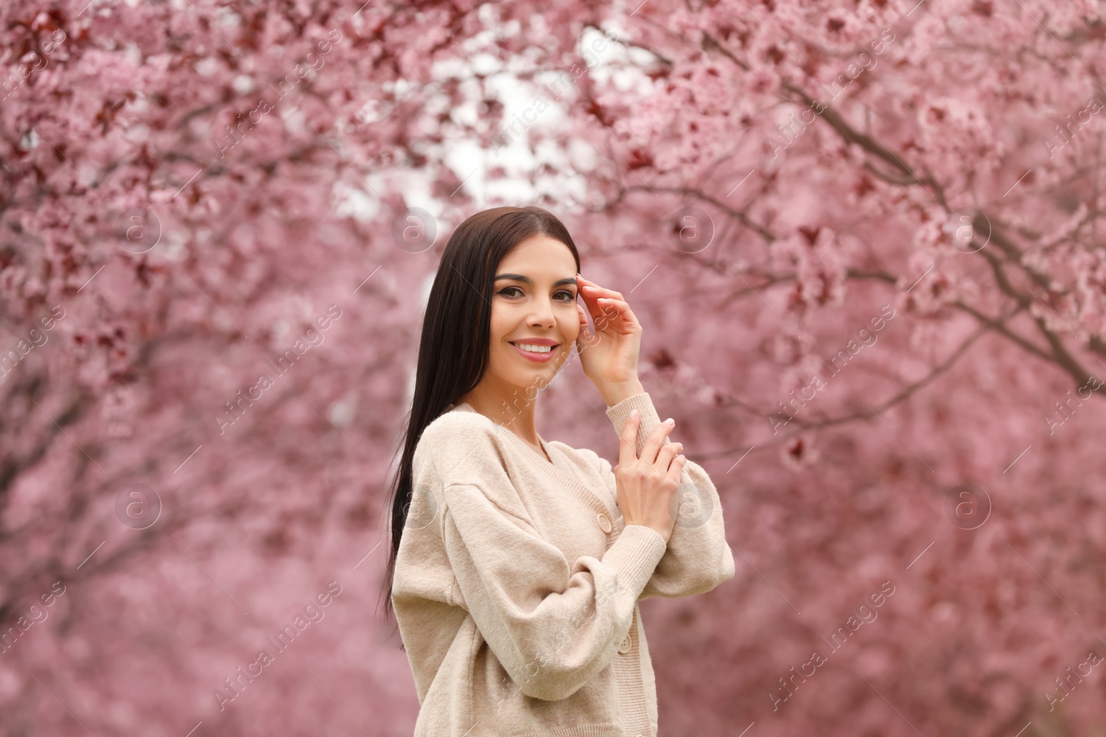 Photo of Pretty young woman in park with blooming trees. Spring look