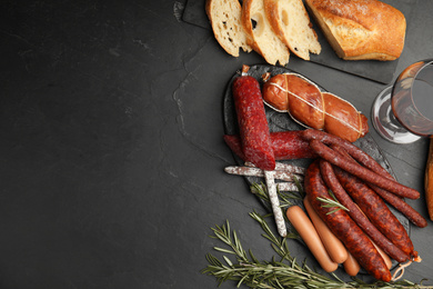 Photo of Different tasty sausages on black table, flat lay. Space for text