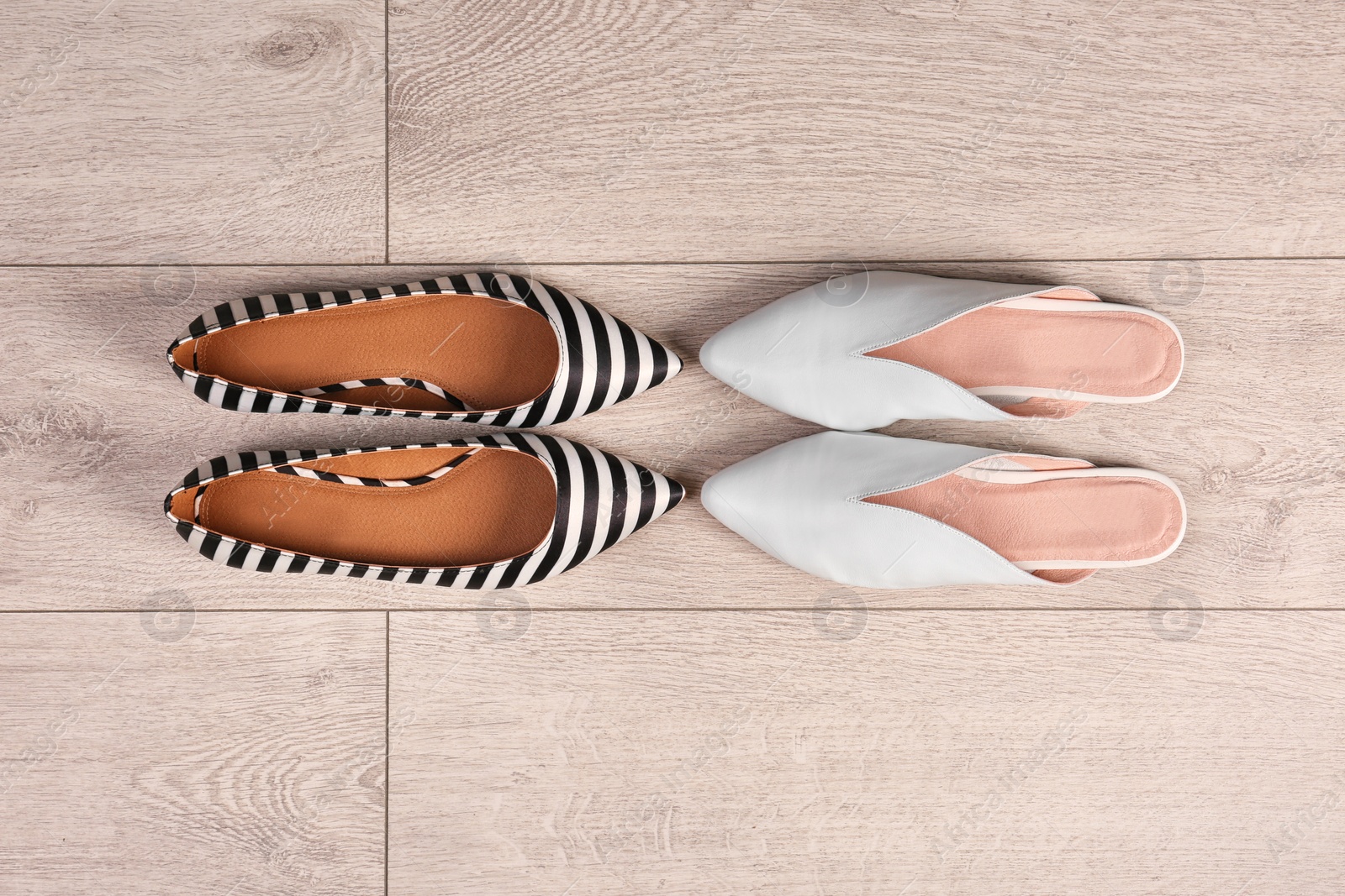 Photo of Different female shoes on wooden background, top view