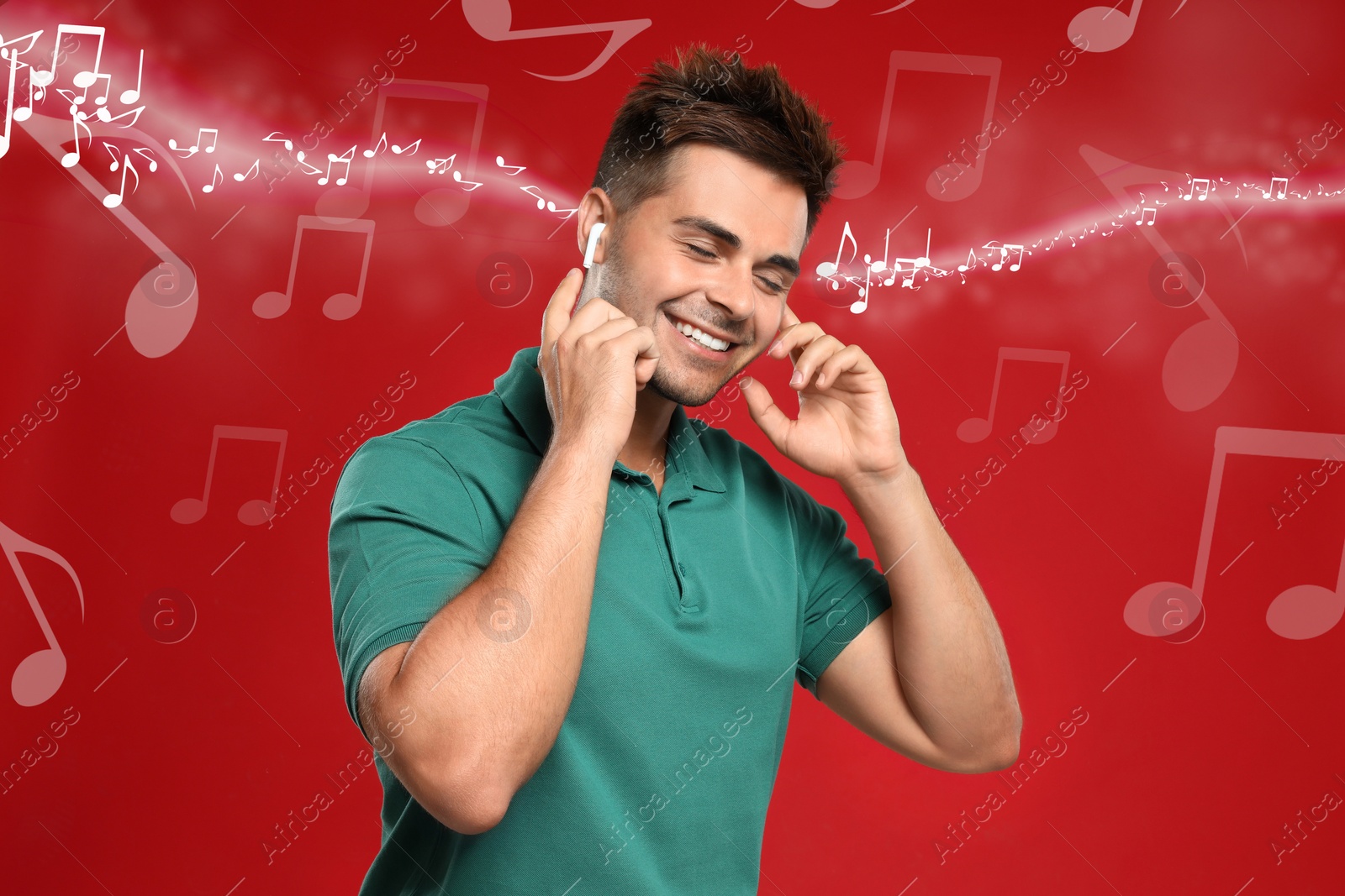 Image of Happy man listening to music on red background. Music notes illustrations flowing from earphones