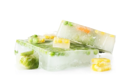 Photo of Fresh vegetables frozen in ice cubes on white background