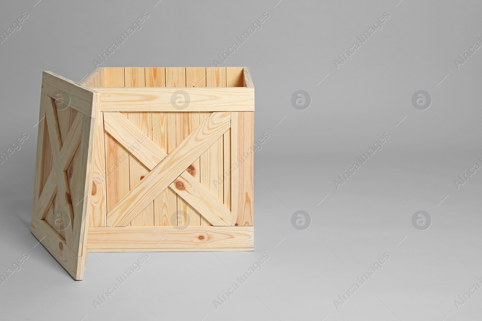 Photo of Open wooden crate on grey background. Space for text