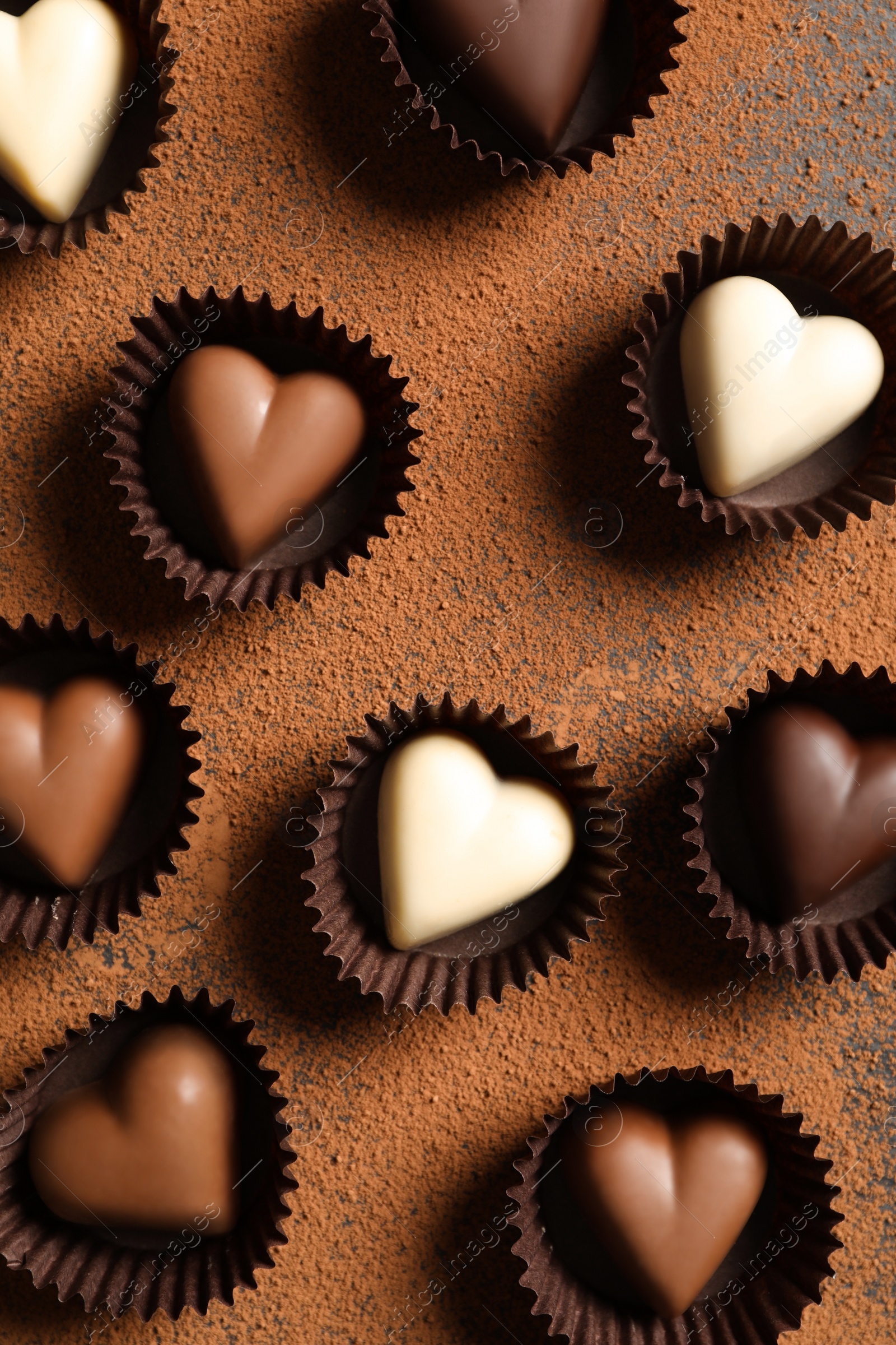 Photo of Beautiful heart shaped chocolate candies on table, flat lay