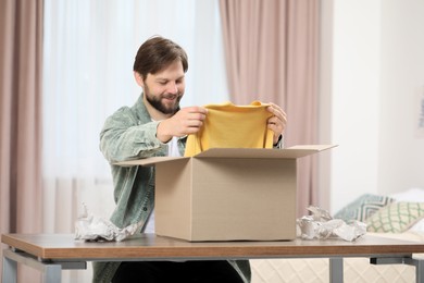 Photo of Happy man with parcel at home. Internet shopping