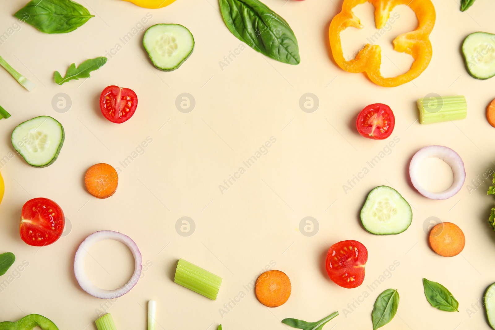 Photo of Frame made with fresh salad ingredients on beige background, flat lay. Space for text