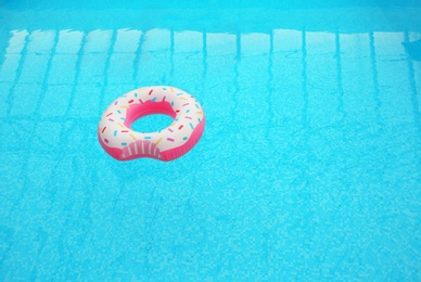 Inflatable ring floating on water in swimming pool