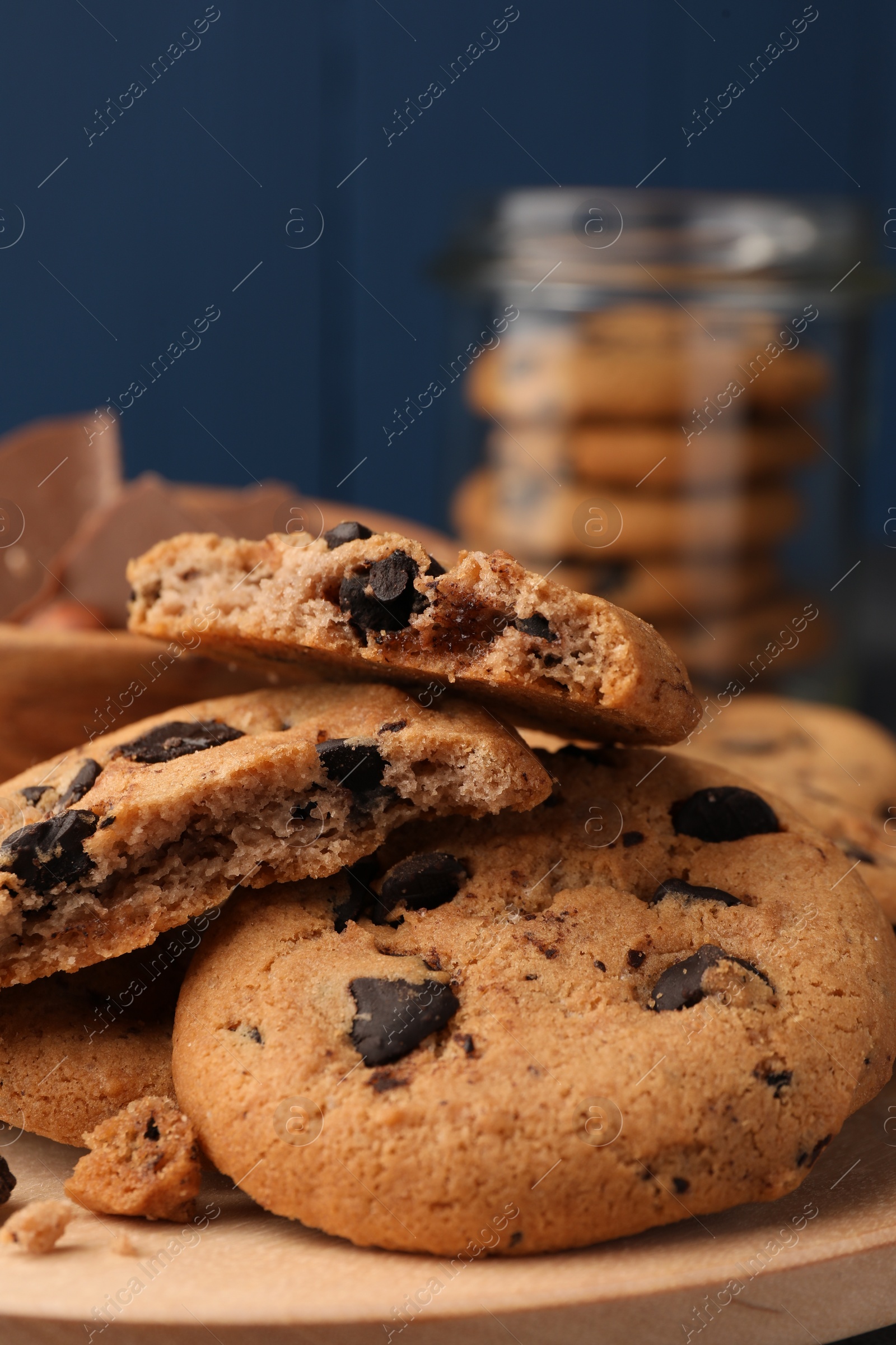 Photo of Delicious chocolate chip cookies on wooden tray, closeup