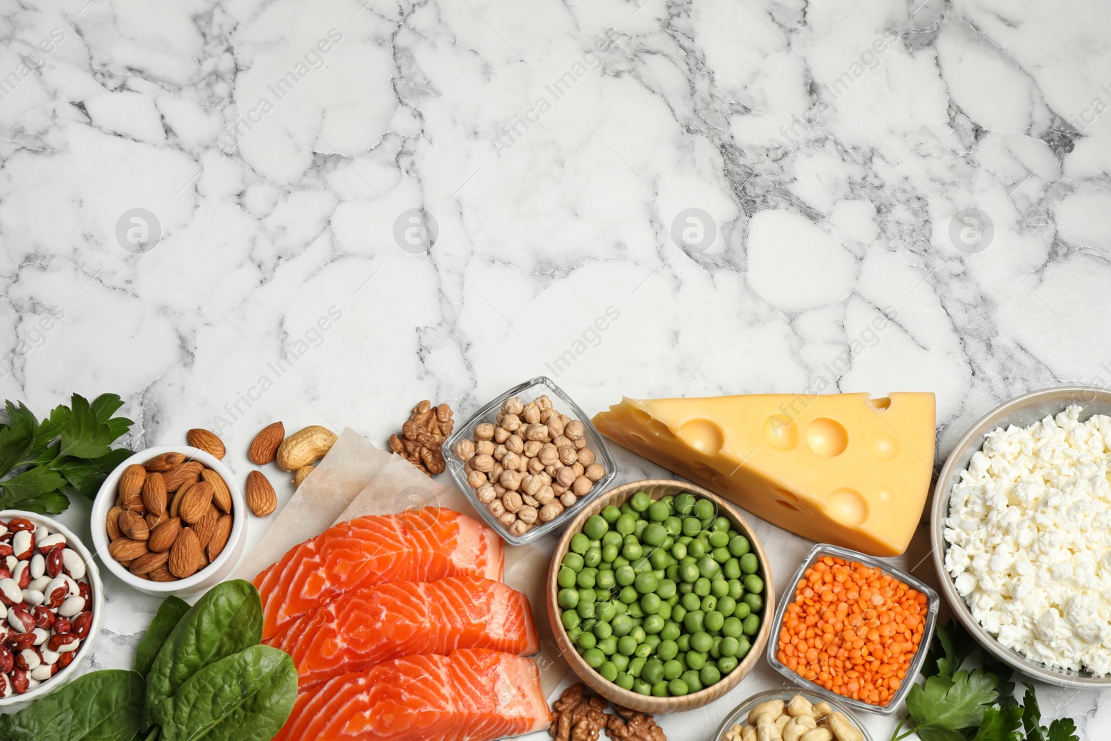 Photo of Products rich in protein on white marble table, flat lay. Space for text