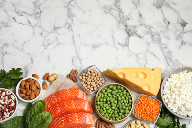 Photo of Products rich in protein on white marble table, flat lay. Space for text