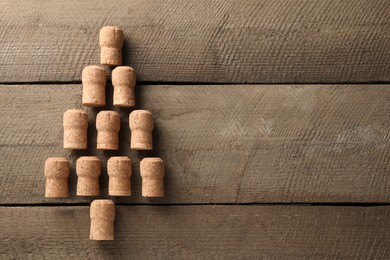 Photo of Christmas tree made of sparkling wine corks on wooden table, top view. Space for text