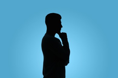 Photo of Silhouette of anonymous man on light blue background