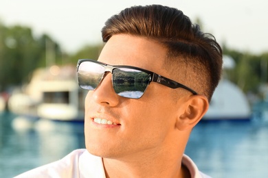 Image of Happy man on vacation. Mountains and lake mirroring in his sunglasses