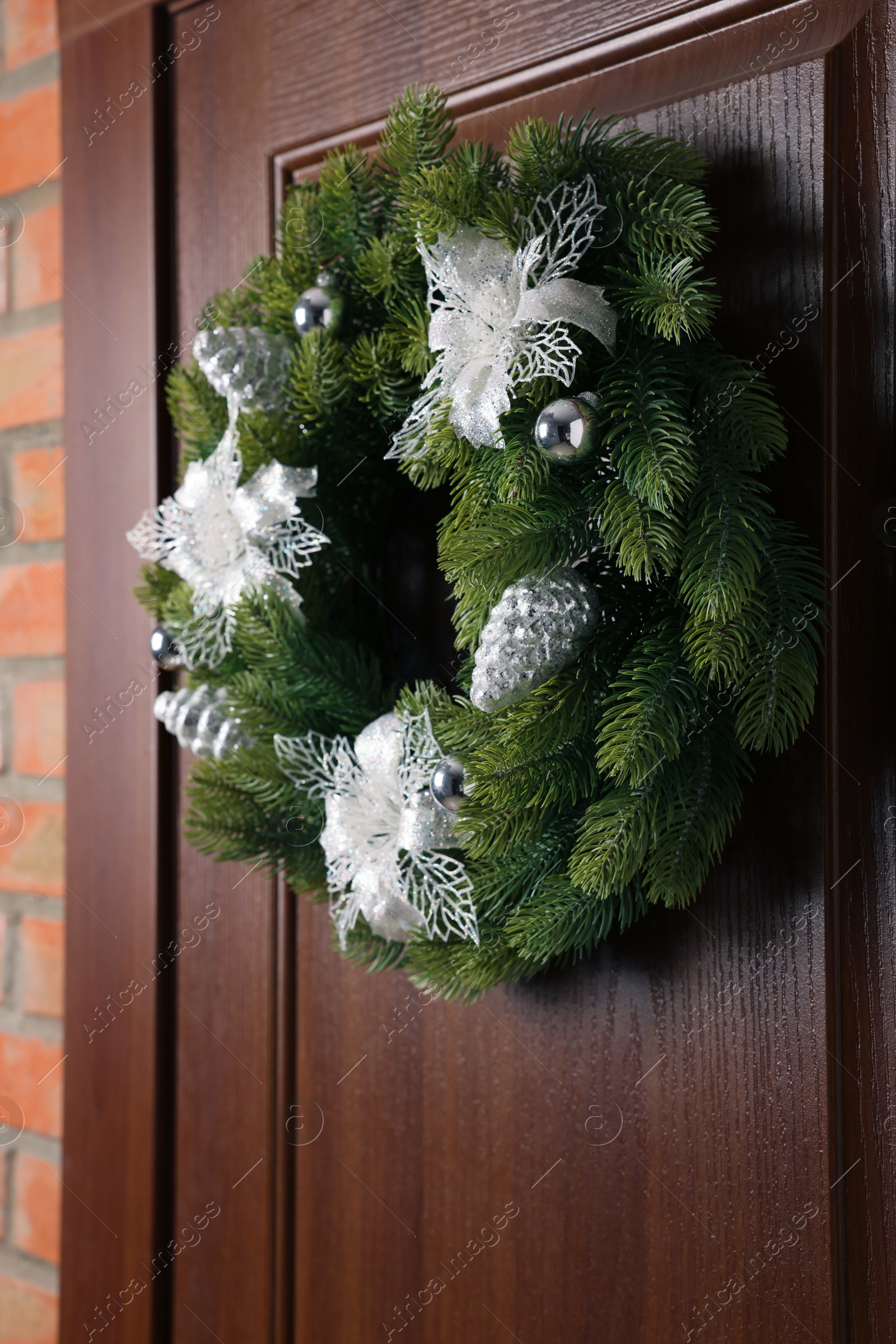 Photo of Beautiful Christmas wreath with festive decor hanging on wooden door