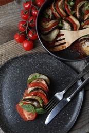 Delicious ratatouille served with basil on wooden table, flat lay