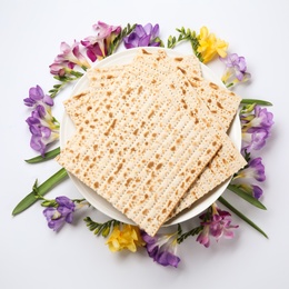 Photo of Composition of matzo and flowers on light background, top view. Passover (Pesach) Seder