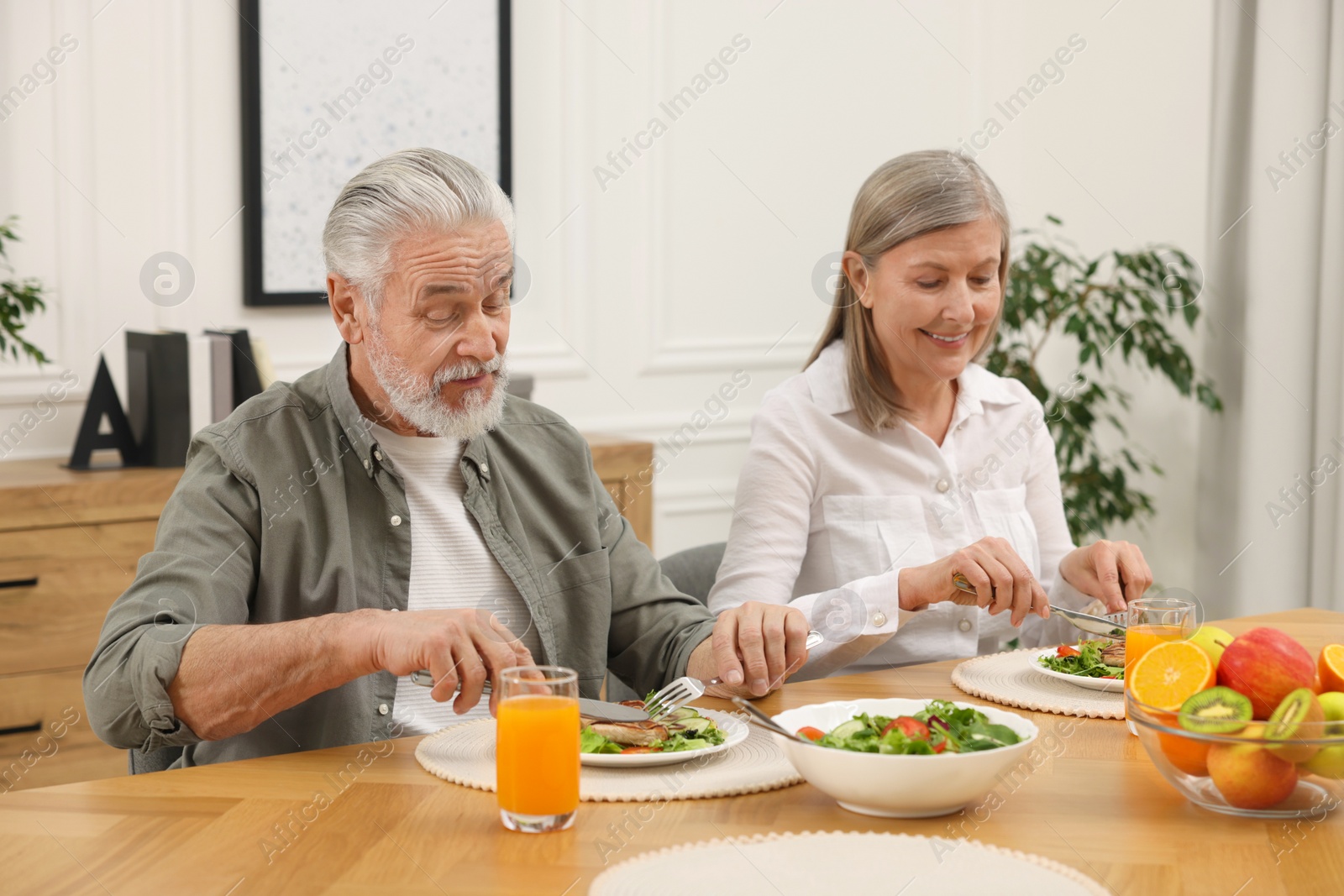 Photo of Happy senior couple having dinner at home