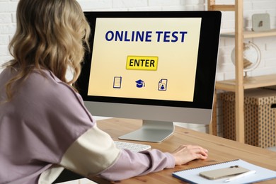 Photo of Woman taking online test on computer at desk indoors