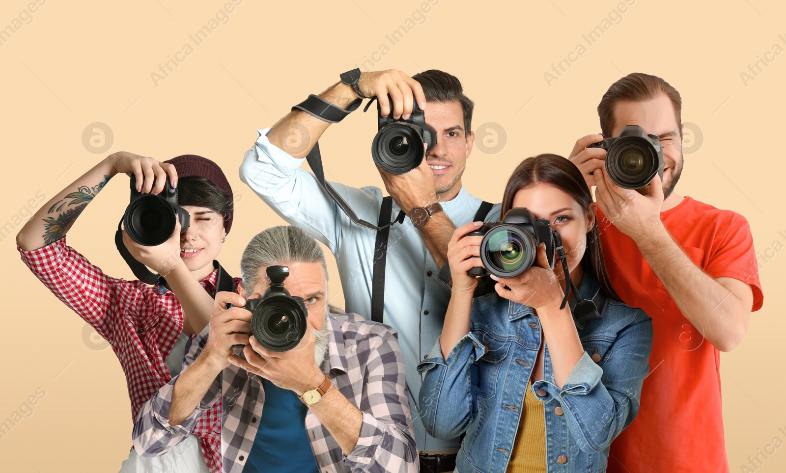 Image of Group of professional photographers with cameras on beige background