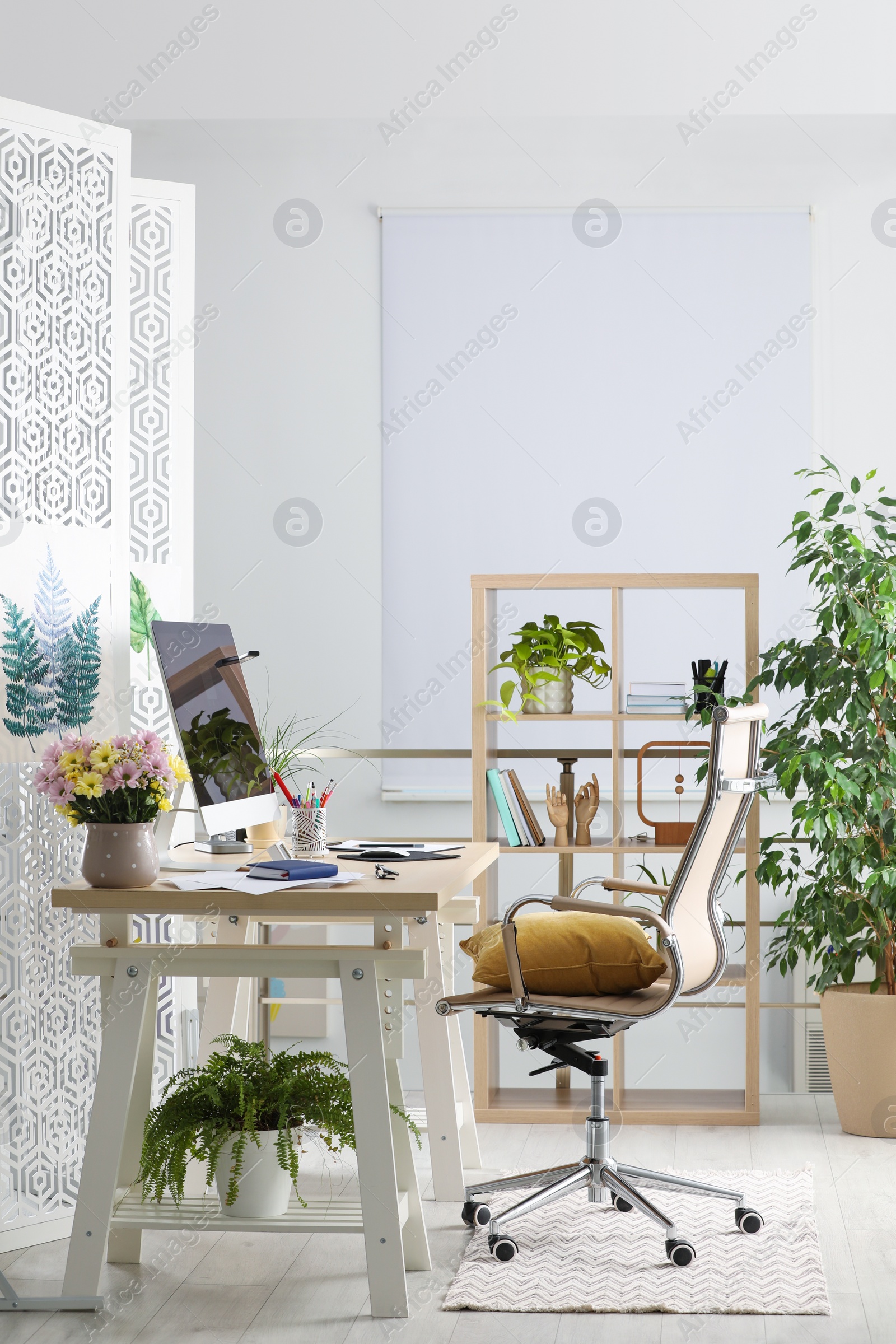 Photo of Comfortable workplace with modern computer and stylish furniture in room. Interior design