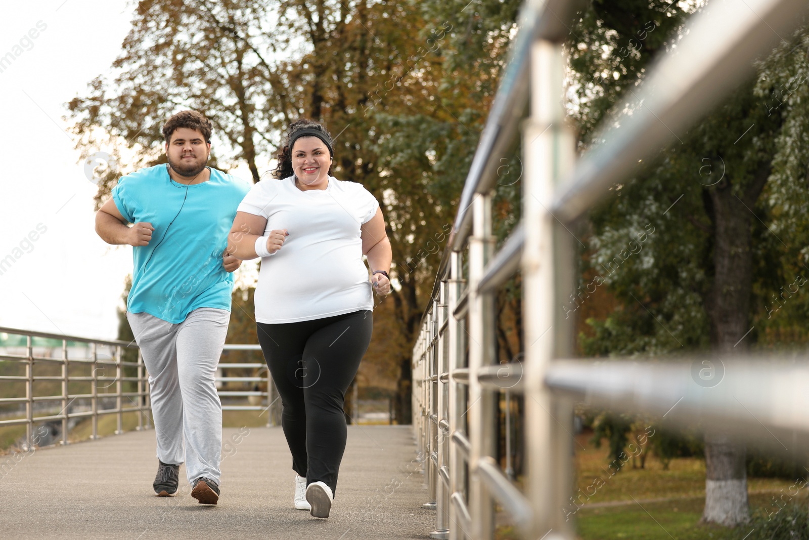 Photo of Overweight couple running together in park