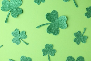 St. Patrick's day. Decorative clover leaves on green background, flat lay